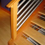 A wooden and metal staircase with wood handrails.