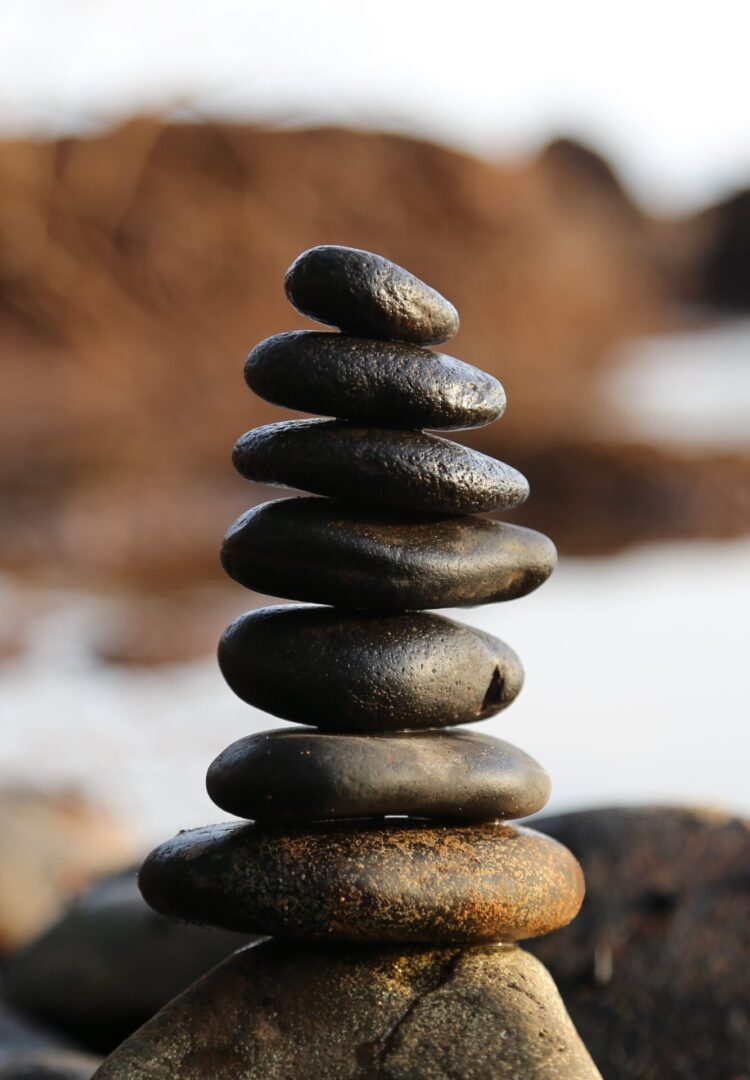 Stack of smooth stones balanced on top of each other with a blurred background.