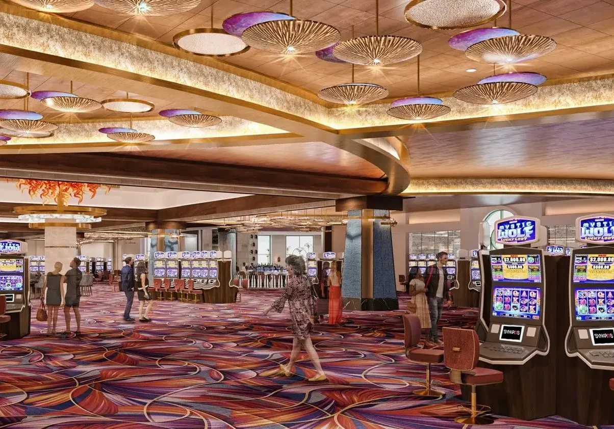 Spacious casino floor with slot machines and decorative ceiling.