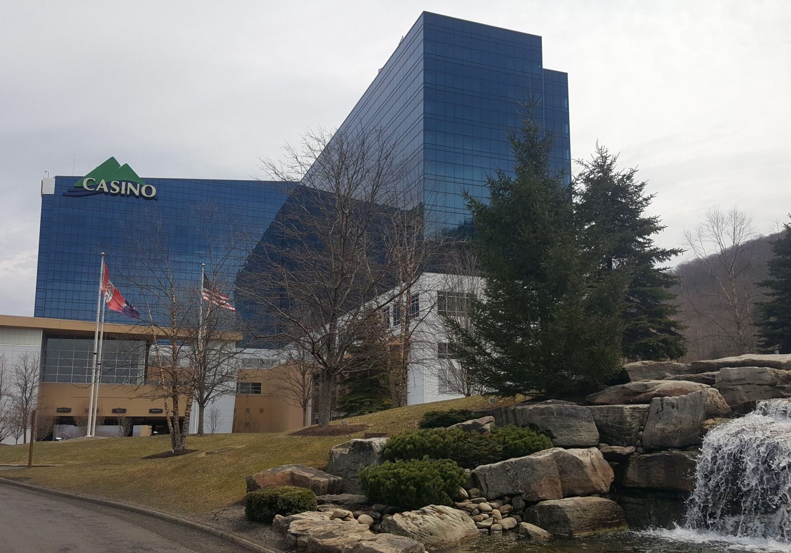 Modern casino building with a cascading artificial waterfall in the foreground.