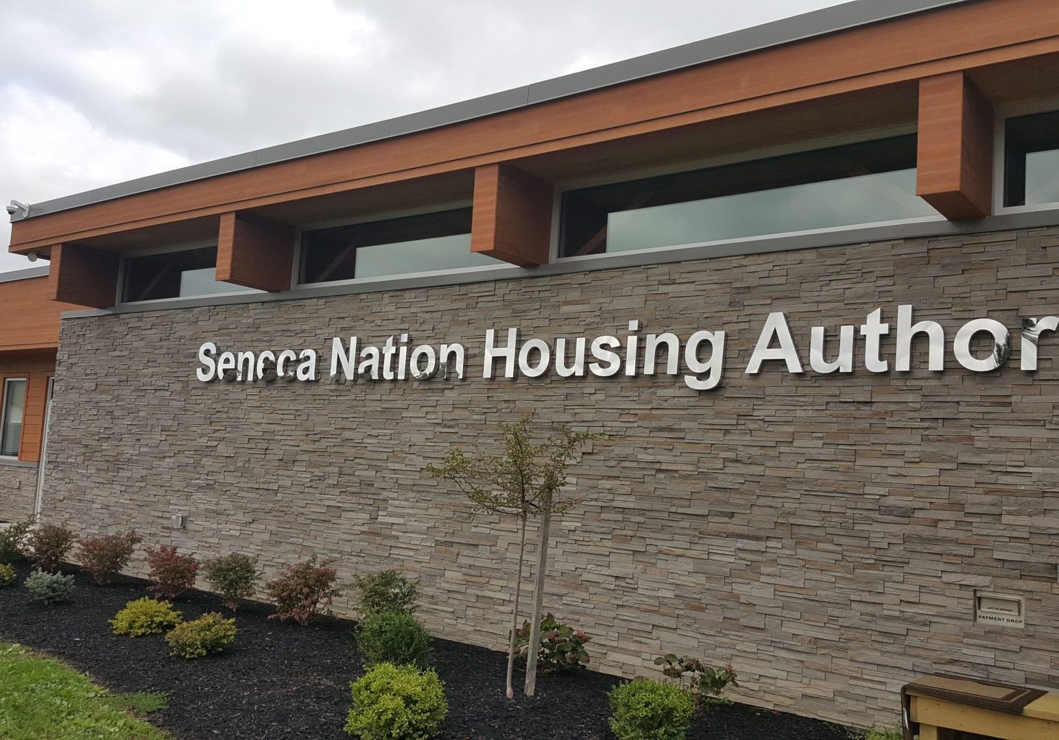 Exterior of the seneca nation housing authority building with stone facade and signage.