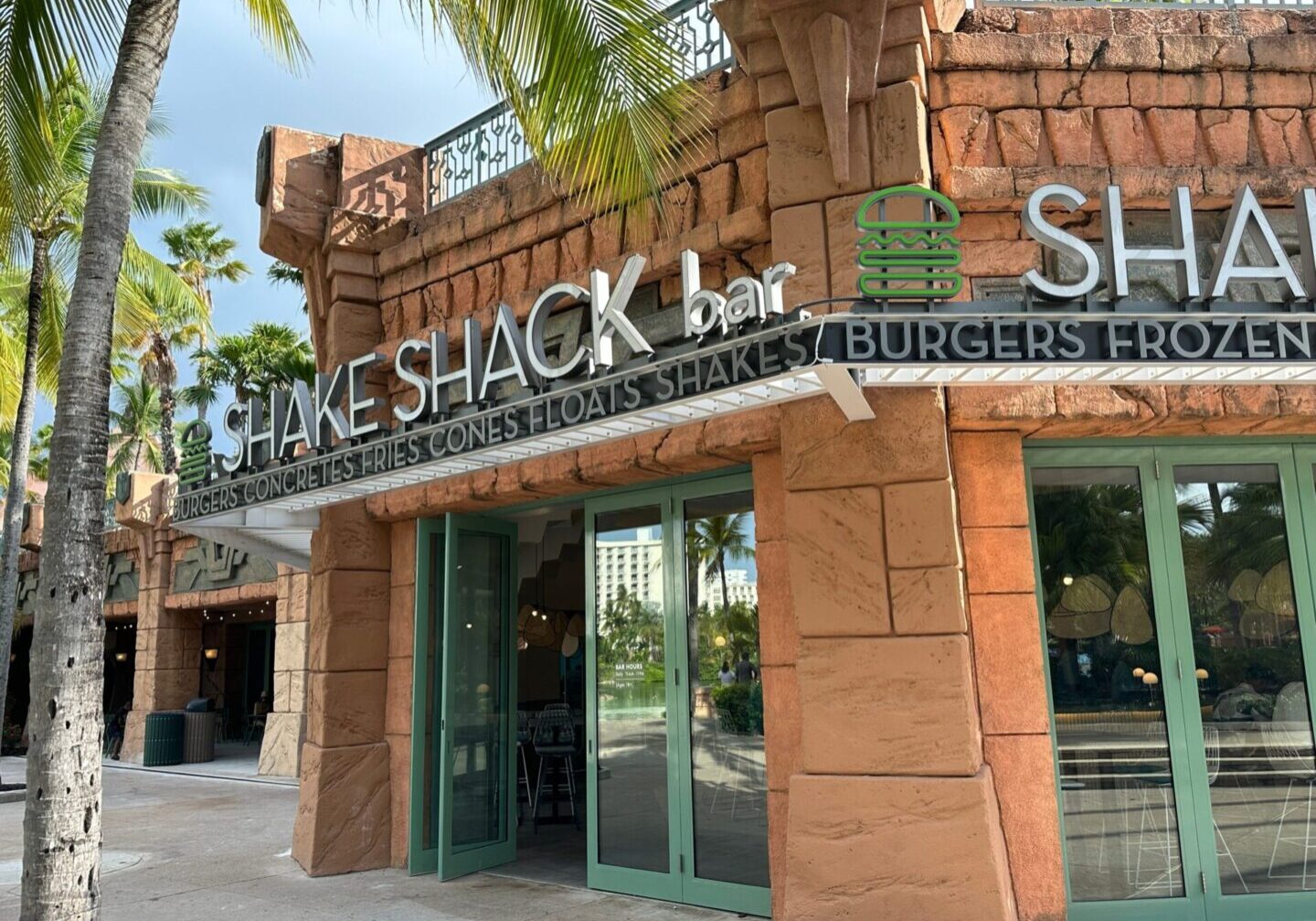 Shake shack bar and restaurant exterior with signage displaying menu offerings such as burgers and shakes.